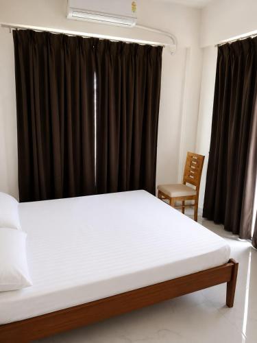 a bedroom with a bed and a black curtain at Auravista in Pālghar