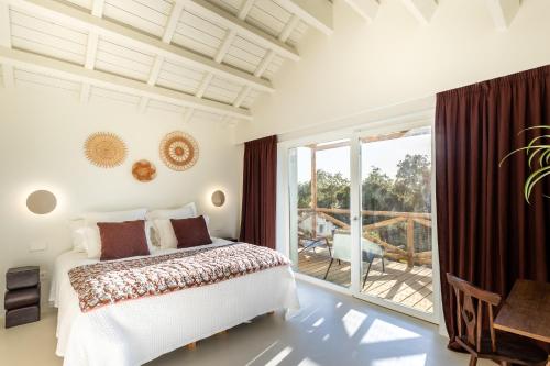 a bedroom with a bed and a balcony at Quinta Amala in Melides