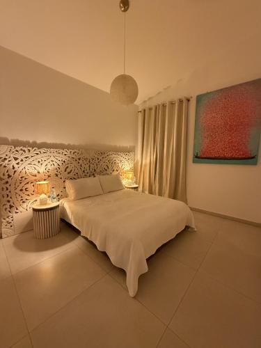 a bedroom with a bed and two tables with lamps at Luxury Casa da Fonte - Private Heated Salt Pool in Faro