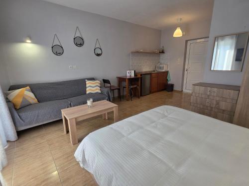 a living room with a bed and a couch and a table at Kos Harmony Apartments in Kefalos