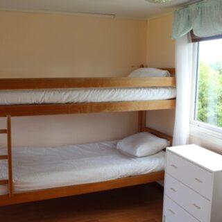 a room with three bunk beds and a window at Sandby Pensionat in Löttorp