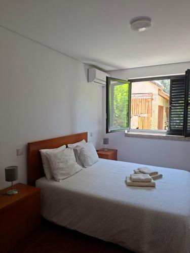 a bedroom with a bed with two towels on it at CabrilHome - AL Gerês in Cabril