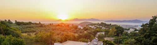 a view of the sun setting over a city at Aroma Zia Residences in Lagoúdi Zía