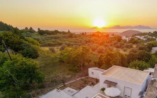 an aerial view of a house with the sunset in the background at Aroma Zia Residences in Lagoúdi Zía