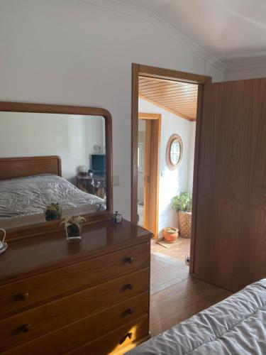 a bedroom with a dresser and a large mirror at Casa dos Ramos in Rio de Fornos