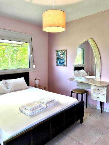 a bedroom with a large bed and a mirror at Zoe By The Sea in Paralia Katerinis