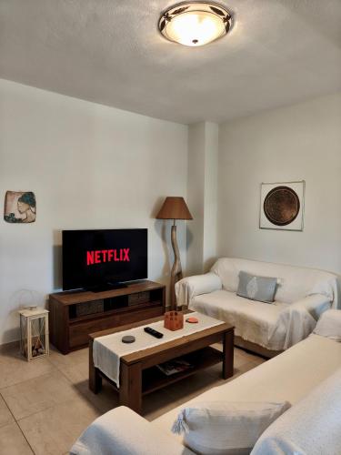 a living room with a tv and a couch at Zoe By The Sea in Paralia Katerinis