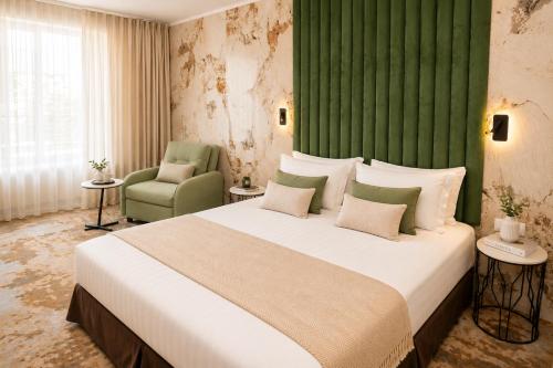 a bedroom with a large bed and a green wall at Hotel Central in Sunny Beach