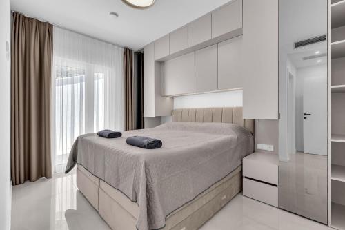 a bedroom with a bed and a large window at Apartman A Villa Legato in Tučepi