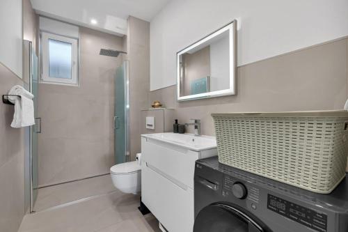 a bathroom with a washing machine and a sink at Apartman A Villa Legato in Tučepi