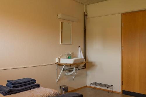 a bathroom with a sink and a mirror at FarNorth Hostel in Bakkafjörður