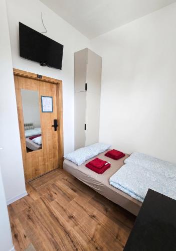 a bedroom with two beds and a flat screen tv at Mini nocleg przy dworcu in Tomaszów Mazowiecki