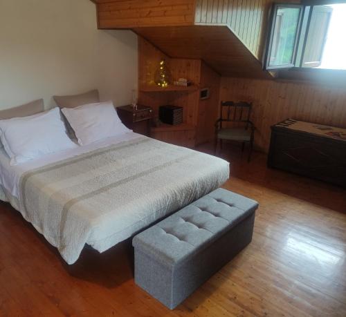 a bedroom with a large bed and a stool at Dal Grof in Tualis
