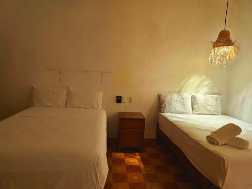 a bedroom with two beds and a light fixture at Casa Kal'i in Brisas de Zicatela