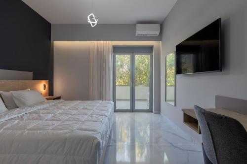 a bedroom with a large bed and a television at Kardamili Beach Hotel in Kardamyli
