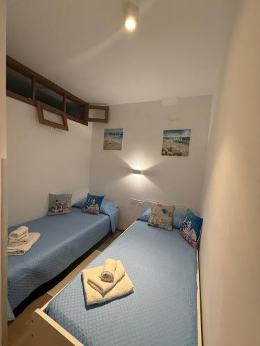 two twin beds in a room with blue sheets at Tropea Home Free Private Parking in Tropea
