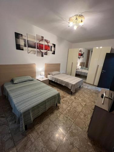a bedroom with two beds and a mirror at Relax suite in Alessandria