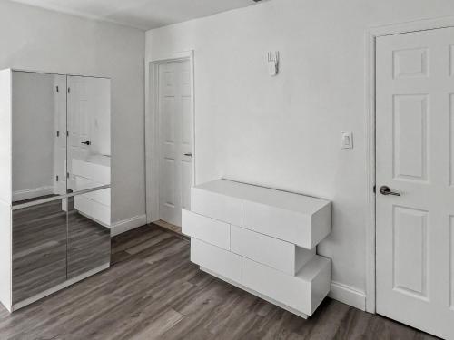 a white bathroom with white cabinets and a mirror at Casa Arya in Howard
