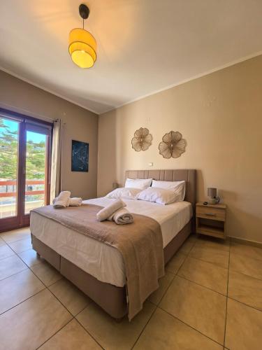 a bedroom with a large bed with towels on it at PetraCasa Luxury Villa in Azolimnos Syros