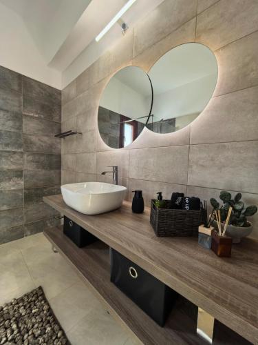 a bathroom with a sink and a mirror at PetraCasa Luxury Villa in Azolimnos Syros