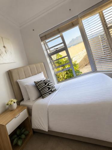 a bedroom with a large bed and a window at De Ocean Lane Guest House in Cape Town