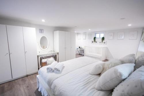a white bedroom with a large white bed with pillows at Minimal 1bed APT basement with free parking in Yonkers