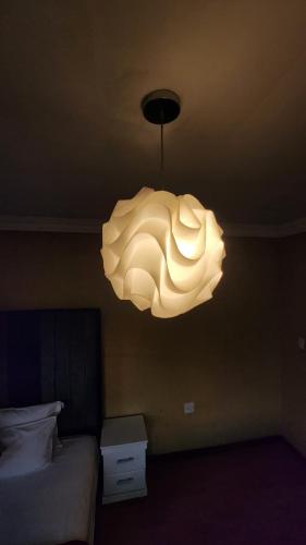 a chandelier hanging from the ceiling in a bedroom at Olympia GuestHouse in Kempton Park