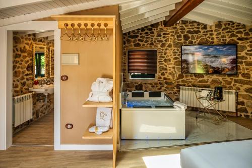 a room with a stone wall with a sink and a counter at Casa de Lema Boutique in Muxia