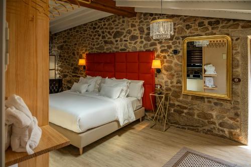 a bedroom with a large bed and a mirror at Casa de Lema Boutique in Muxia