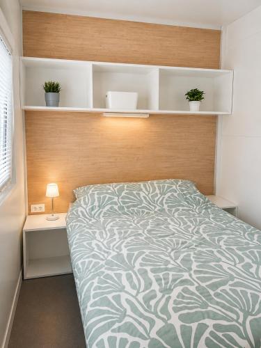 a bedroom with a bed with a wooden headboard and shelves at Hiška Gaia- pool tickets included in Brežice