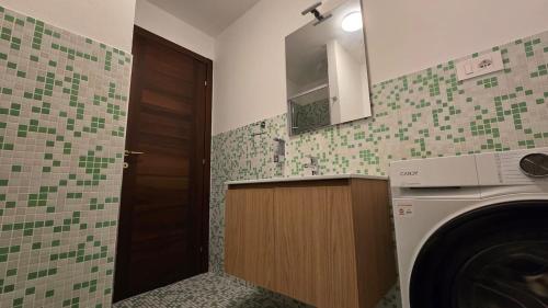 a bathroom with a washing machine and a mirror at Fuga in Valpolcevera Comfort e Relax in Mignanego