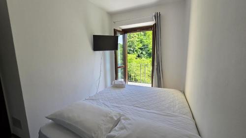 a bedroom with a bed with a window in it at Fuga in Valpolcevera Comfort e Relax in Mignanego