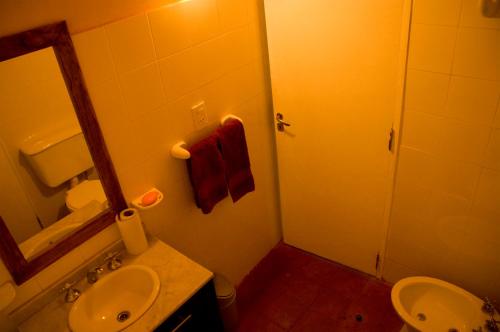 y baño con lavabo, aseo y espejo. en Finca La Colorada en San Salvador de Jujuy
