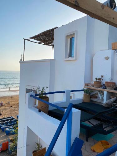 a house on the beach with the ocean in the background at Soft Sand Beach in Taghazout