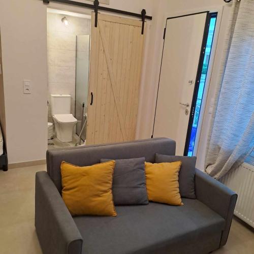 a gray couch with two yellow pillows in a living room at Lydia's Apartment in Tripoli