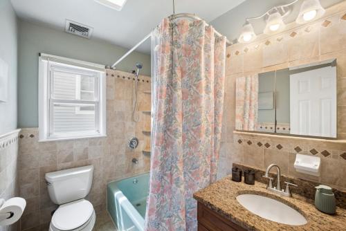 a bathroom with a toilet sink and a shower at Retro 3BR Walkup Apt and Shared Yard and Parking in Yonkers