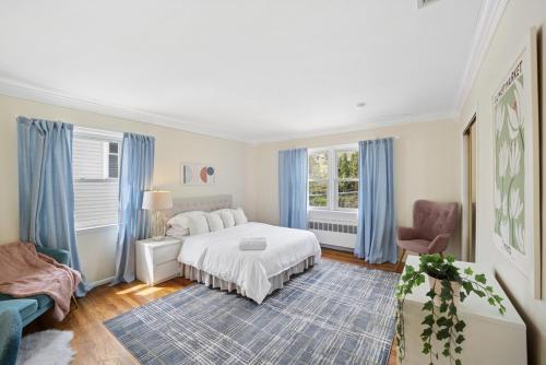 a bedroom with a white bed and blue curtains at Retro 3BR Walkup Apt and Shared Yard and Parking in Yonkers