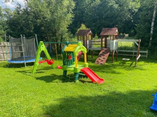 a childrens playground with a slide and a play set at Domki że Hej Bieszczady in Ustrzyki Dolne