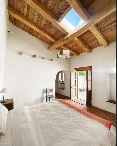 a large bedroom with a large bed and wooden ceilings at Hosteria Villa Cardon in Cachí