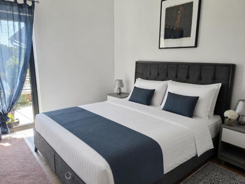 a bedroom with a large bed with blue and white pillows at Sarajevo Hills-POOL&JACUZZI private garden Home-Near Old Town in Sarajevo