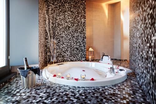 a bath tub in a bathroom with a tiled floor at Dharma Luxury Hotel in Rome