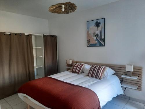 a bedroom with a white bed with a red blanket at Le Gite Boho in Vendeuvre-du-Poitou
