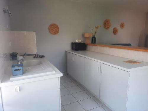 a kitchen with white cabinets and a sink at Le Gite Boho in Vendeuvre-du-Poitou