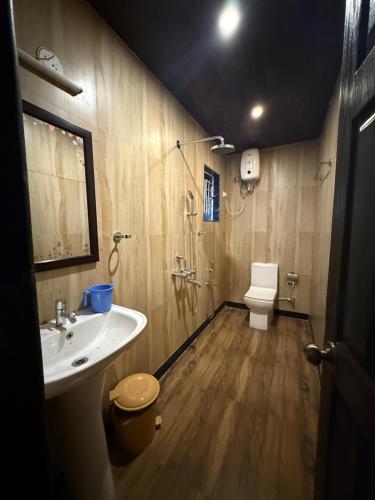 a bathroom with a sink and a toilet at Baga Beach Palm Cottage in Calangute