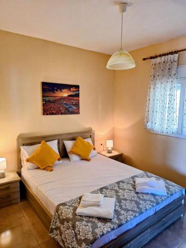 a bedroom with a large bed with yellow pillows at Lemon tree House in Skala Marion