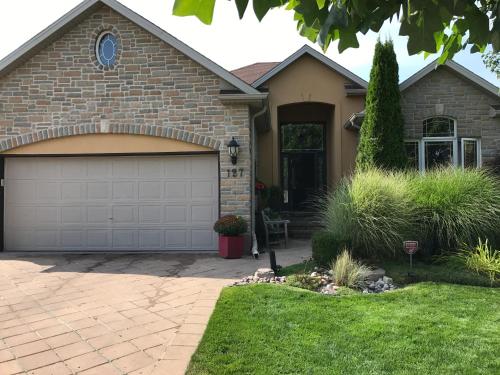 a brick house with a garage at Quiet Cozy Luxury on the Thames in Ontario! in London