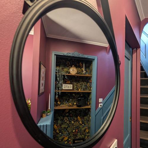 a mirror in a room with a shelf filled with items at Le Boudoir d'Héloïse in Breux Jouy