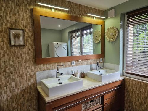 a bathroom with two sinks and a large mirror at Cottage Fonsorbes RDC Maison in Fonsorbes