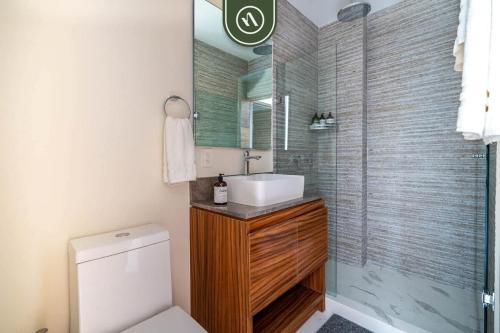a bathroom with a toilet and a sink and a shower at 3BR Condo Right Next to the Beach - Pool - Palapa in Nuevo Vallarta