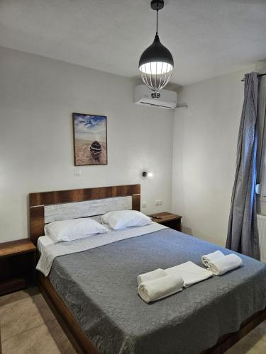 a bedroom with a bed with two towels on it at Iliokalli Apartment in Nea Peramos